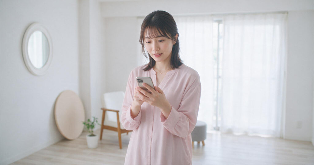 生理や体調不良による当日の休みをスマートフォンで連絡する女性
